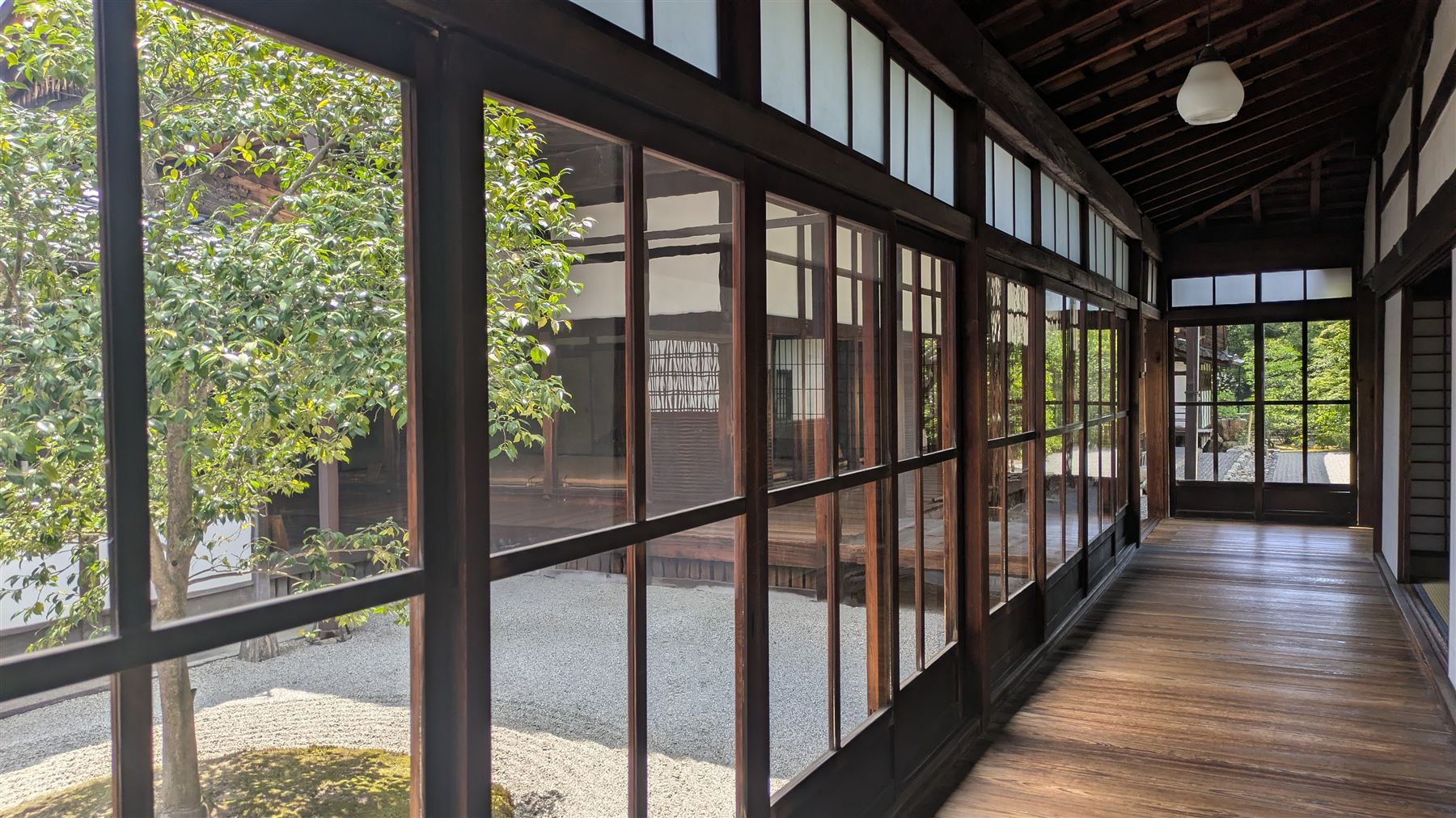 A wooden corridor beside a gravel garden
